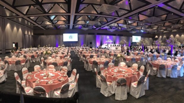 Banquet gala): "Ballroom AV setup by Event Audio Visual Services (EAV) featuring dual projection screens, uplighting, and full gala dinner layout.