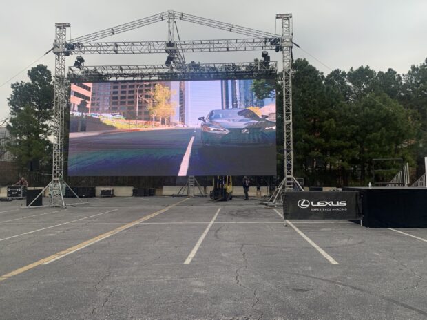Large outdoor LED wall on truss system displaying Lexus content at open-air event