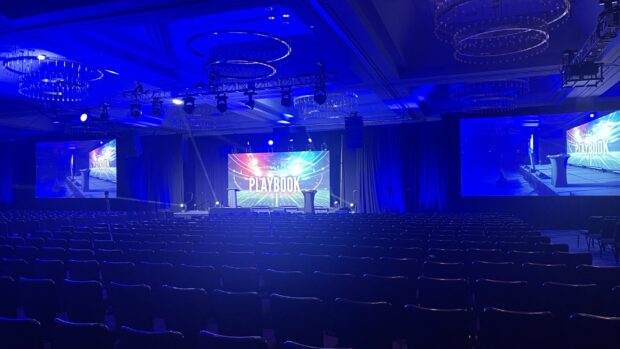 Empty conference stage with “Playbook” display